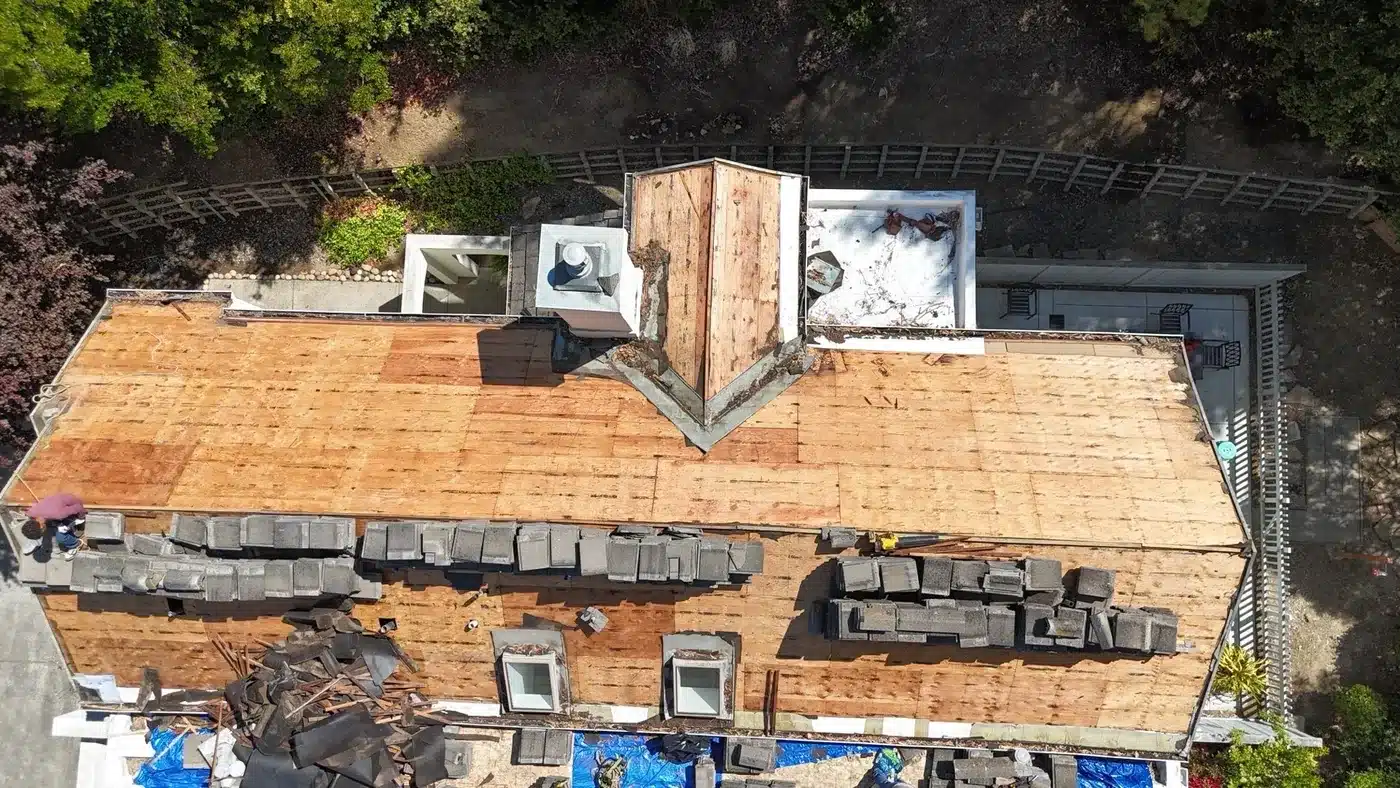 Aerial view of concrete tile stacked on the exposed roof deck during the re-lay, Vallejo HOA