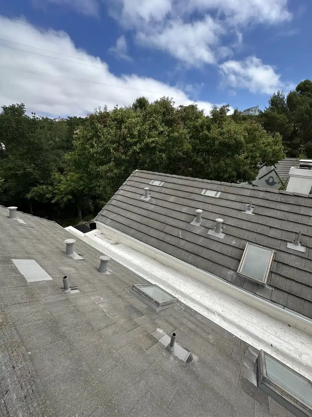 Re-laid concrete tile roof beside a rebuilt coated low-slope section on a Vallejo townhome