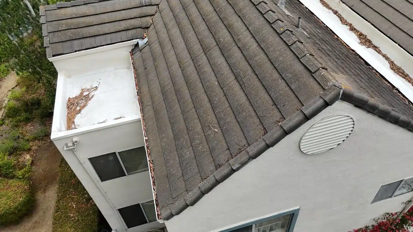 Low-slope roof section meeting concrete tile on a Vallejo townhome before the re-lay