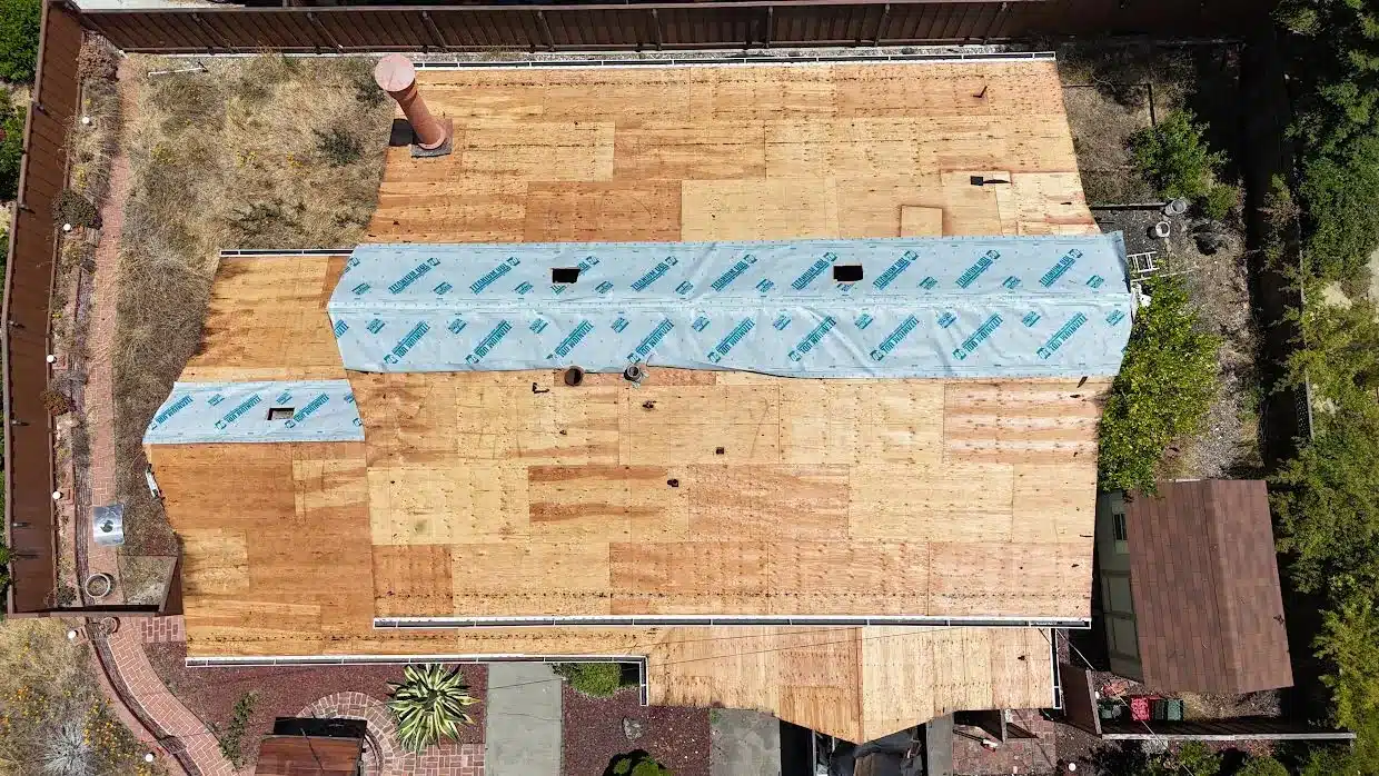 Overhead view of new plywood decking covering the whole roof with synthetic underlayment along the ridge, Proctor Road, Castro Valley CA