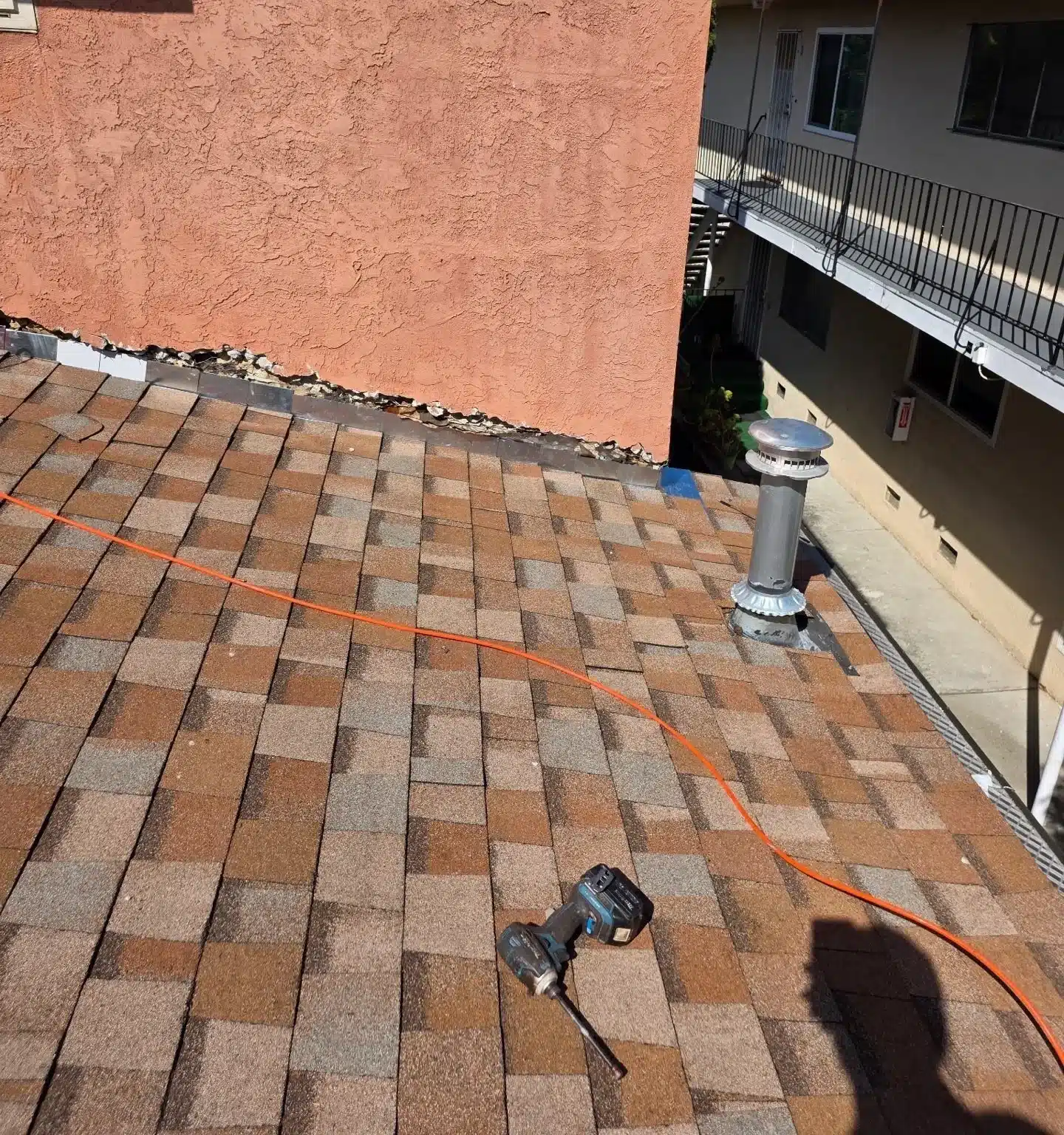 New multi-tone shingles finished up to a stucco wall on the Berkeley roof section