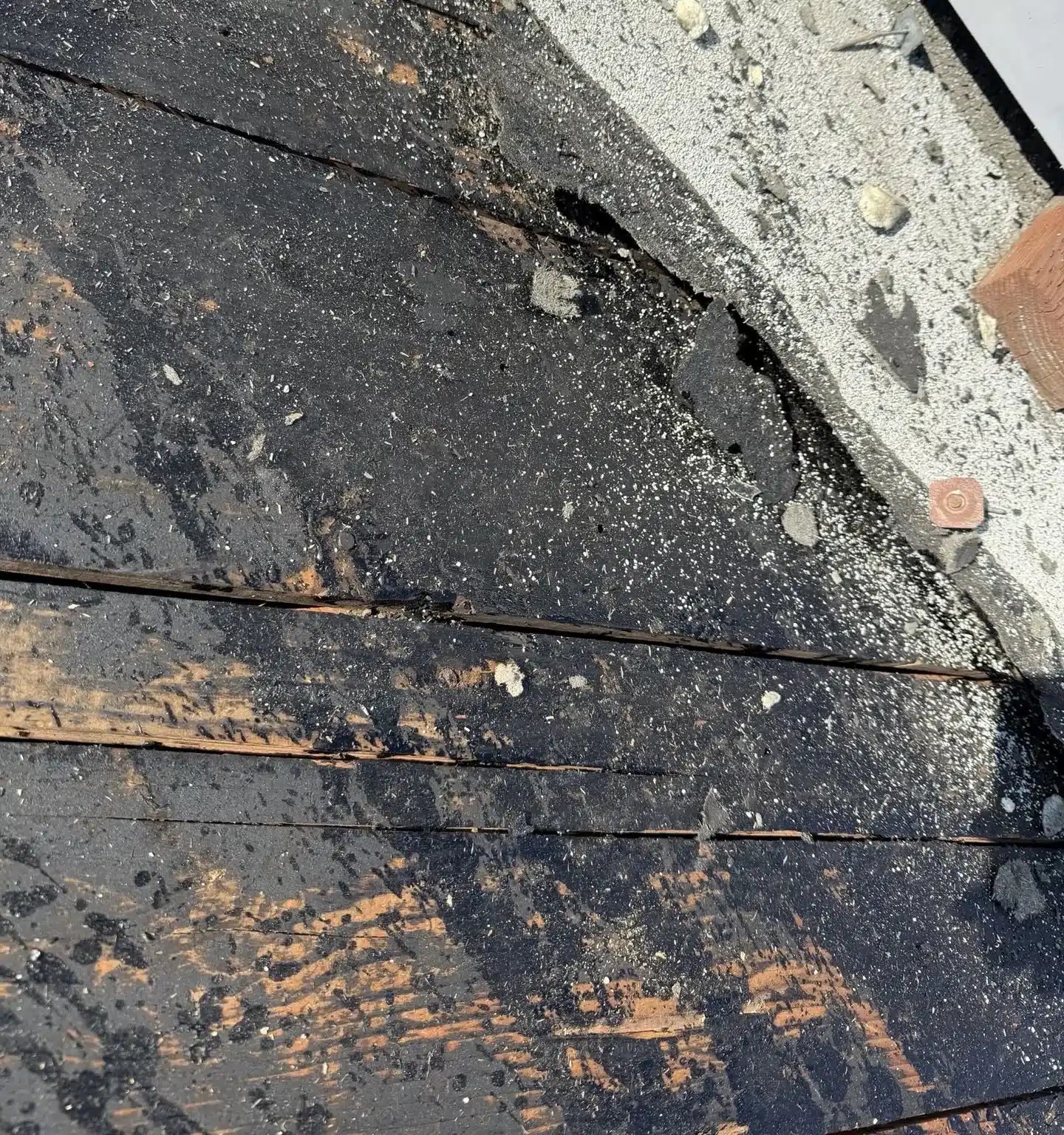Failed built-up roof with bare weathered plank decking exposed on a commercial building in Rodeo CA