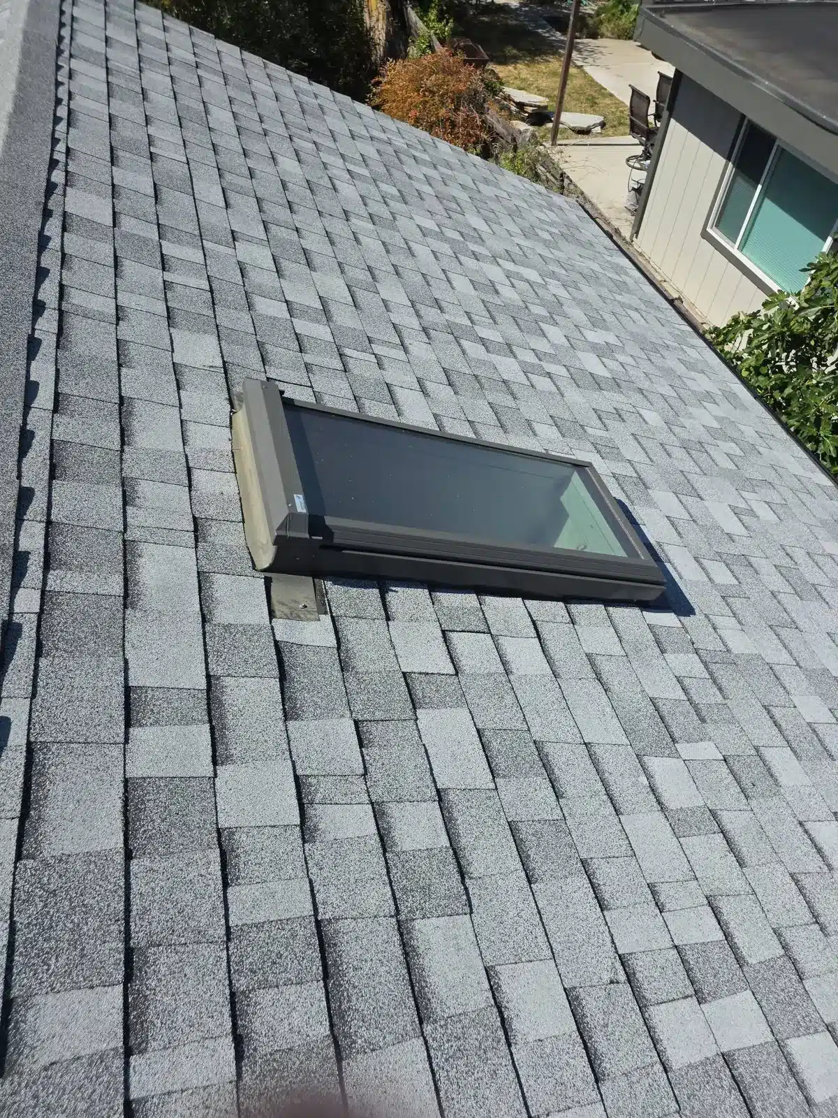 Close view of a new skylight flashed into new gray architectural shingles in Pleasant Hill