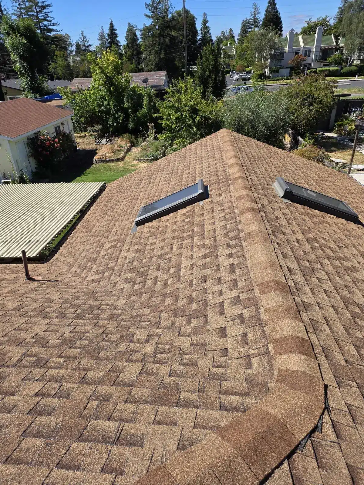 Original brown asphalt shingle roof with two aging skylights on a single-story home in Pleasant Hill before replacement
