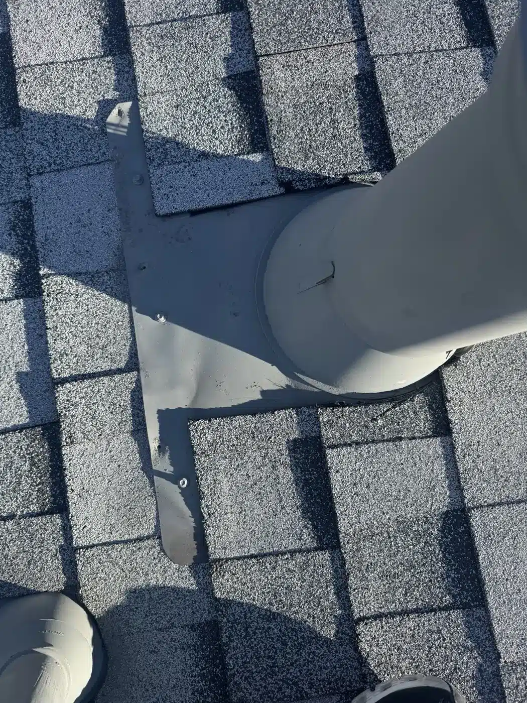 Close-up of a new pipe flashing worked into cool-rated shingles in San Jose