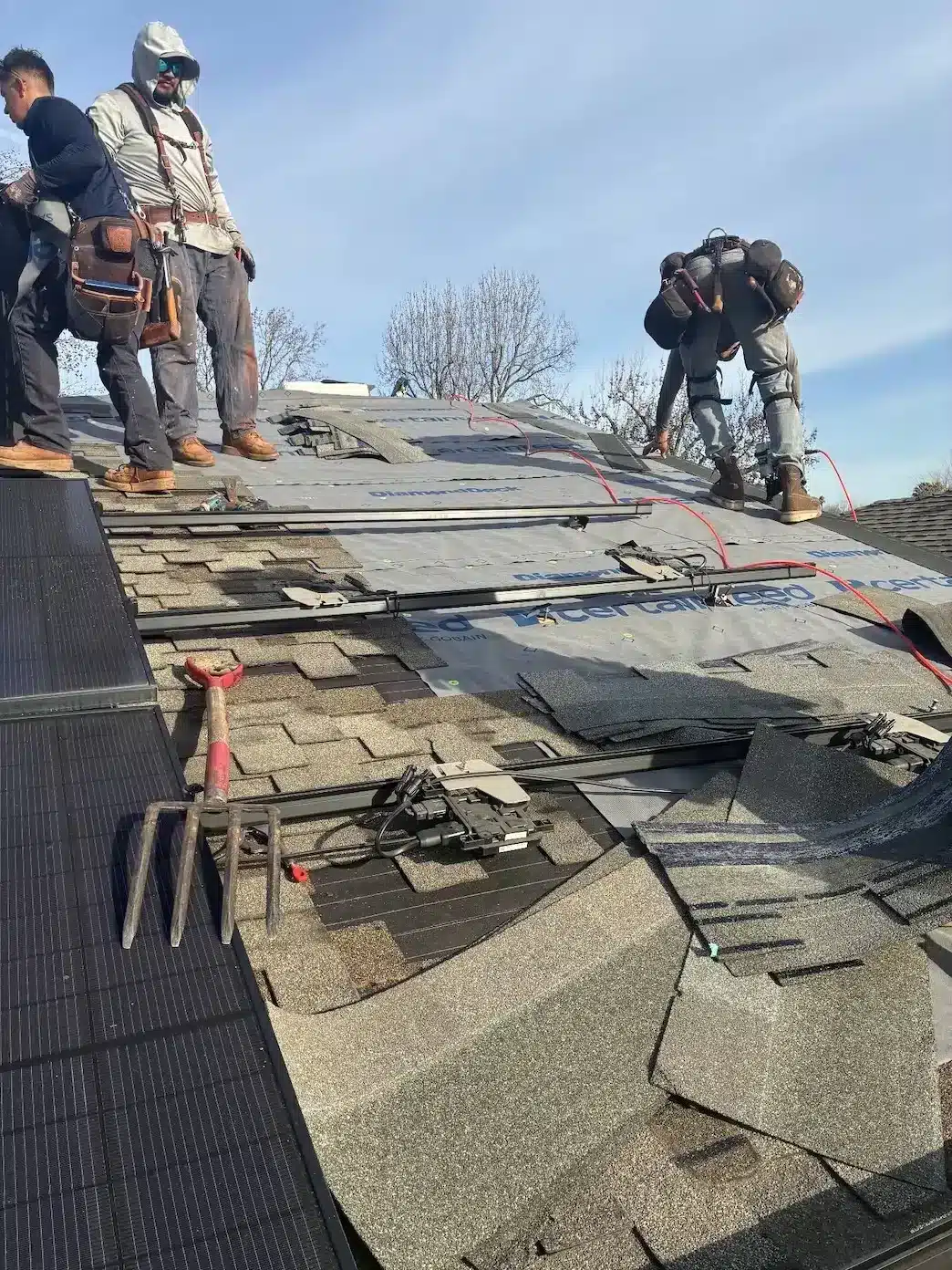 Crew installing CertainTeed DiamondDeck synthetic underlayment around solar rails during a San Jose roof repair